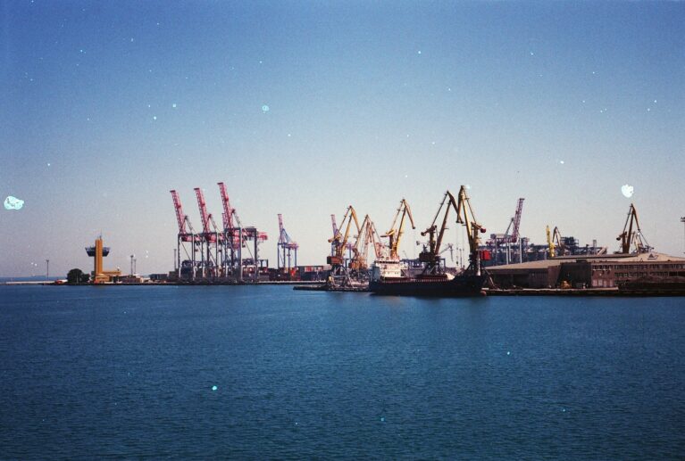 boats and cranes near sea during daytime