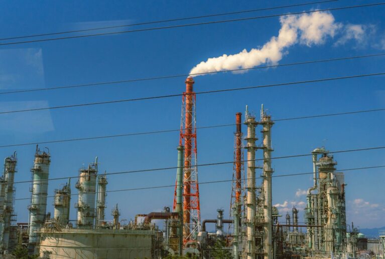 Industrial factory with smoke billowing from chimney.
