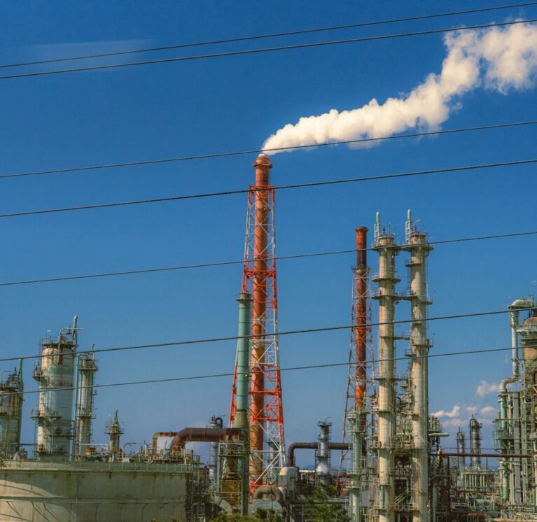 Industrial factory with smoke billowing from chimney.