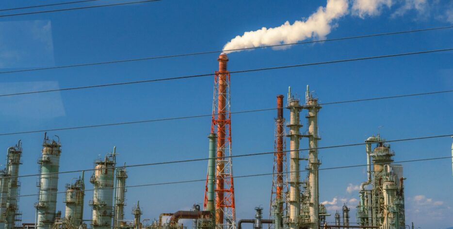 Industrial factory with smoke billowing from chimney.